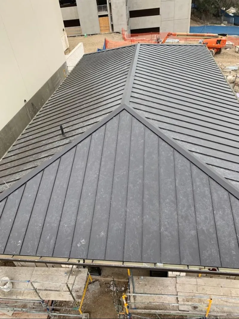 Commercial metal roof construction with crane equipment in Clinton